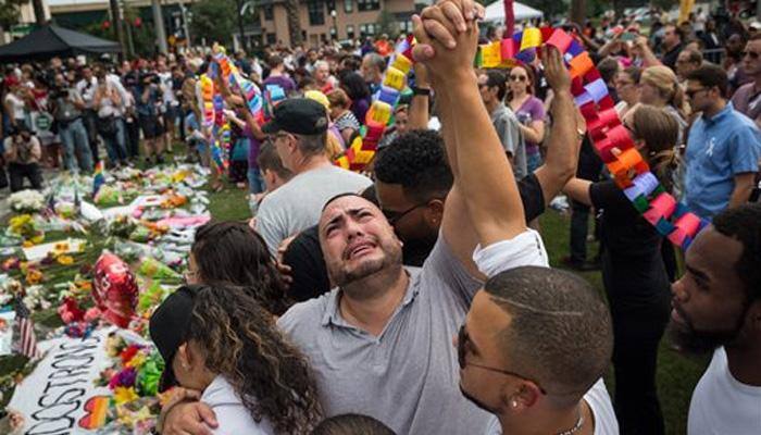 Candles, tears and song at Orlando vigil for massacre victims