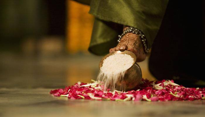 Hindu bride gently pushes a Kalash full of rice with her foot during Graha Pravesh– Here’s why