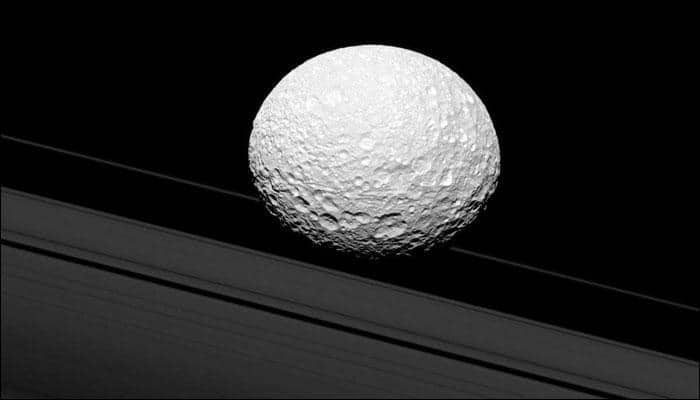 Moon Mimas creates illusion of proximity with Saturn&#039;s rings as Cassini clicks!