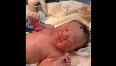 Newborn baby holds mother's birth control device! Was he born with it?