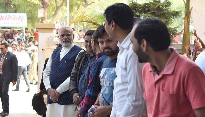 PM Narendra Modi stands in queue to cast vote, touches brother&#039;s feet in Gujarat