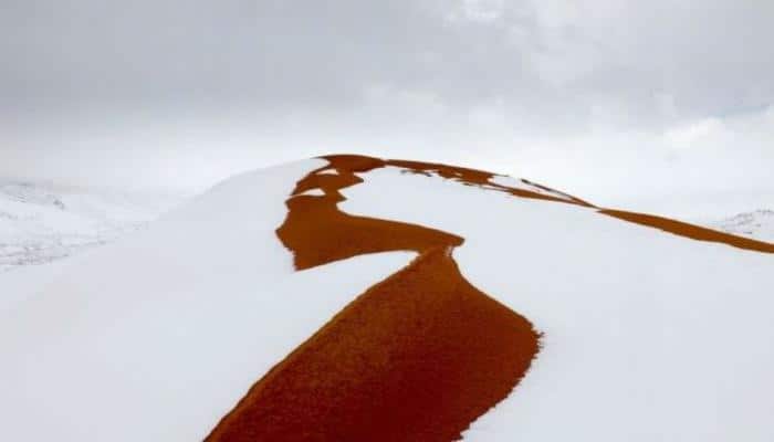 Snow paints red sand dunes of Sahara desert a wondrous white