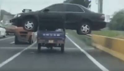 Man carries sedan car on a tiny three-wheeler in China - Video goes viral