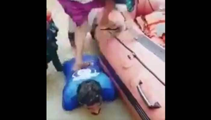 Kerala floods: Man lends back as stair, helps women to get into rescue boat - Watch