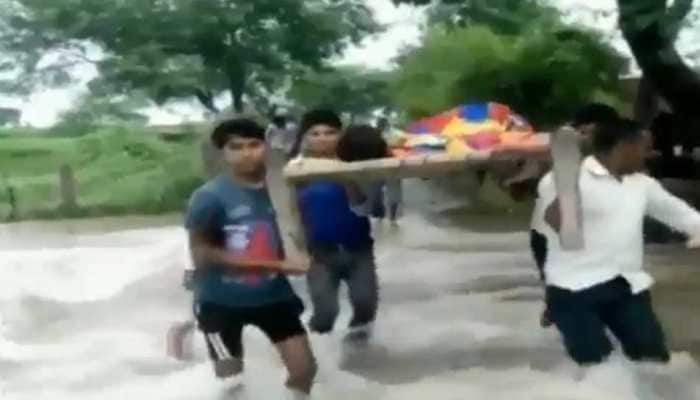 Villagers carry patient on cot due to lack of road connectivity Villagers carry patient on cot due to lack of road connectivity