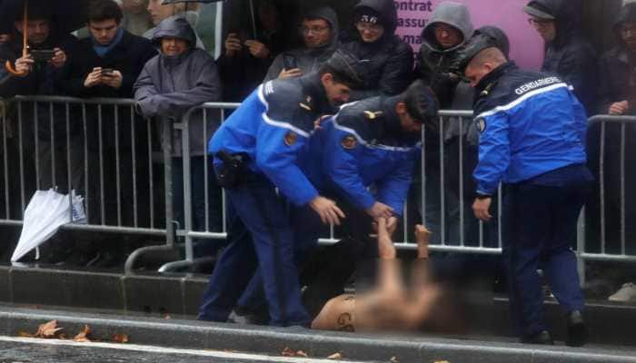 Topless woman protester runs at Donald Trump''s motorcade in Paris