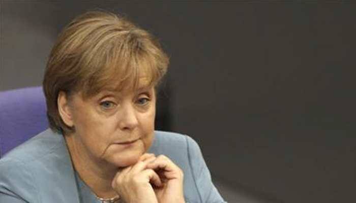 Merkel sits rather than stands at public ceremony, following shaking bouts