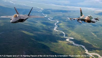 US Air Force F-22 Raptors and F-16 Fighting Falcons fly in formation