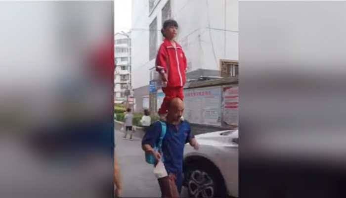 Watch: Chinese girl balances on grandfather's shoulders while on her way to school