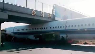 Plane gets stuck under footbridge in China - watch viral video 