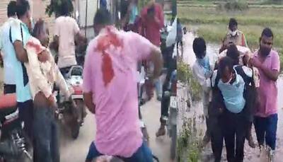 Two policemen carry man injured in stabbing incident over shoulder to hospital in Telangana's Mustabad