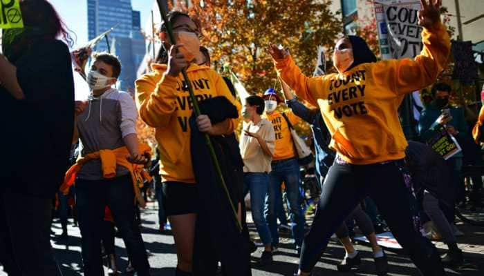 US presidential election results: Some Americans dance, others wield guns outside vote-tallying sites