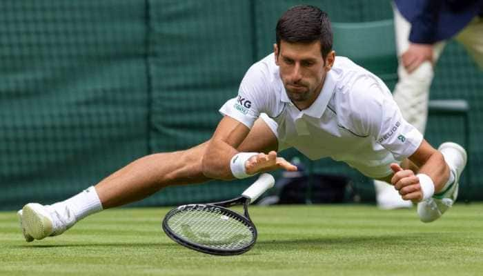 World No. 1 Novak Djokovic slides in to make a return to South Africa's Kevin Anderson in their Wimbledon round two match. (Photo: PTI)