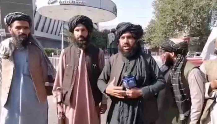 Are you happy? Taliban insurgents with rifle, reporter&#039;s microphone in hand, ask locals