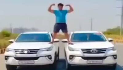 Noida: Ajay Devgn-like stunt on two luxury cars lands 21-year-old youth in jail - Watch Video