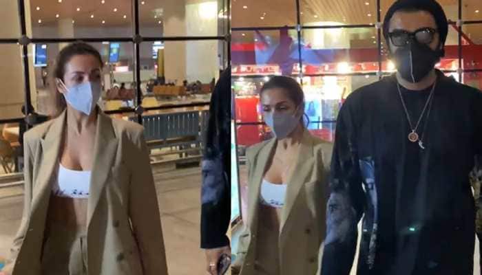 Malaika Arora BRUTALLY trolled for wearing oversized jacket with a bustier top at airport, haters ask &#039;is it snowing in Mumbai?&#039;