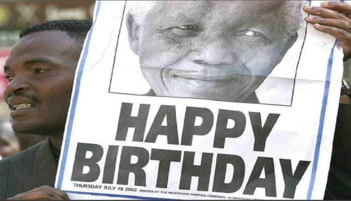 One of the thousands of South African municipal workers carries a poster of former South Africa President Nelson Mandela on a march through a wealthy suburb of Johannesburg July 18, 2002