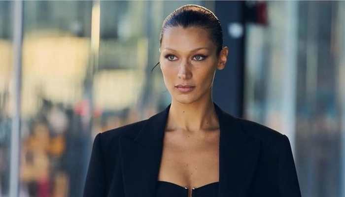 Bella Hadid poses topless as she gets spray-on dress on runway 