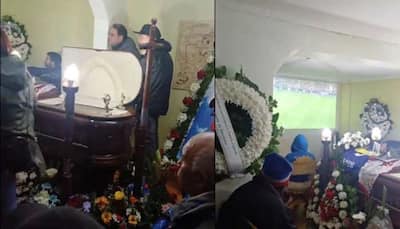 Family Watch Football Sitting Next To Coffin; Unusual Video Goes Viral-Watch