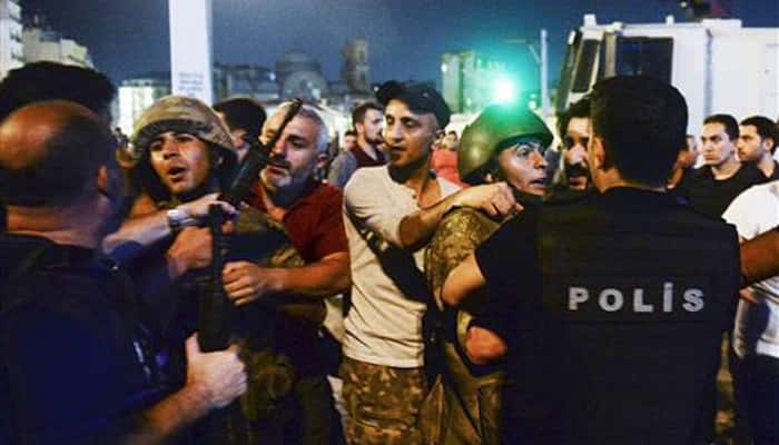 Turkish soldiers, arrested by civilians, are handed to police officers, in Istanbul&#039;s Taksim square.